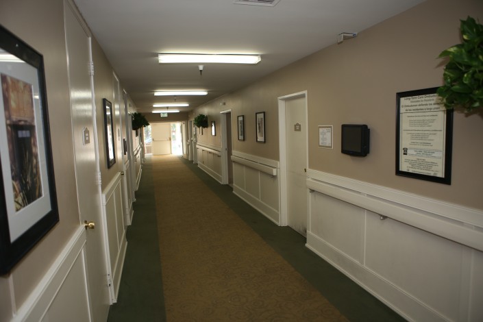A well-lit corridor with doors and wall decorations.