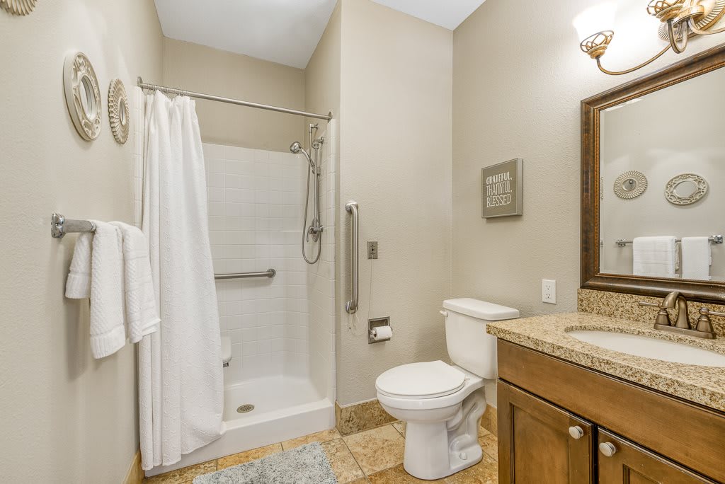A clean and simple bathroom with a shower, toilet, and sink.