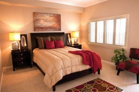A cozy bedroom with a neatly made bed, warm lighting, and elegant decor.