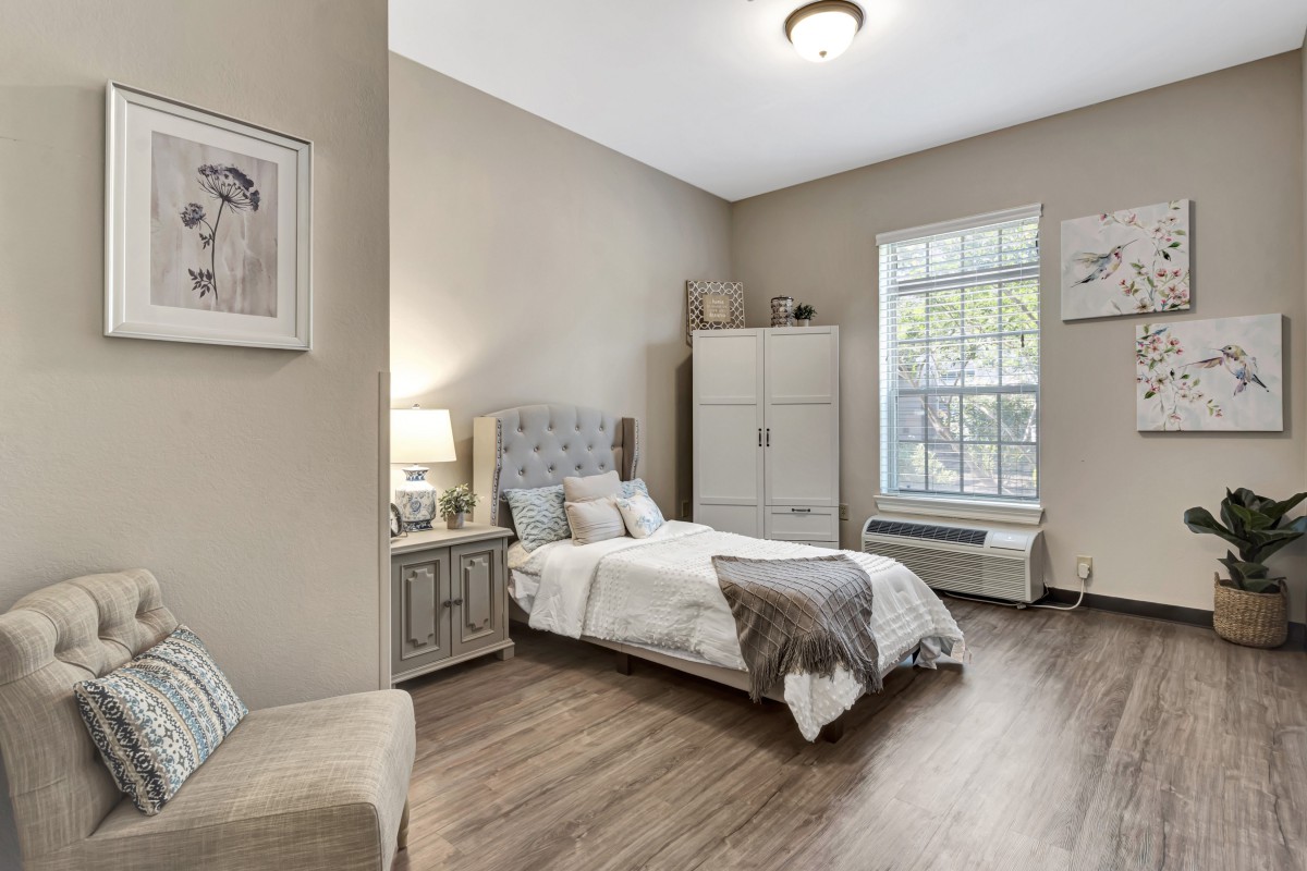 A cozy and modern bedroom with neutral tones, featuring a bed, wardrobe, and wooden flooring.