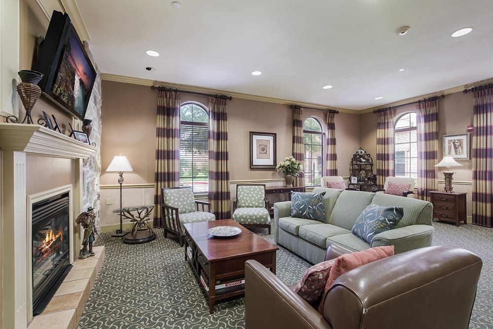 A cozy living room with a comfortable sofa and coffee table, complemented by large windows and stylish decor.
