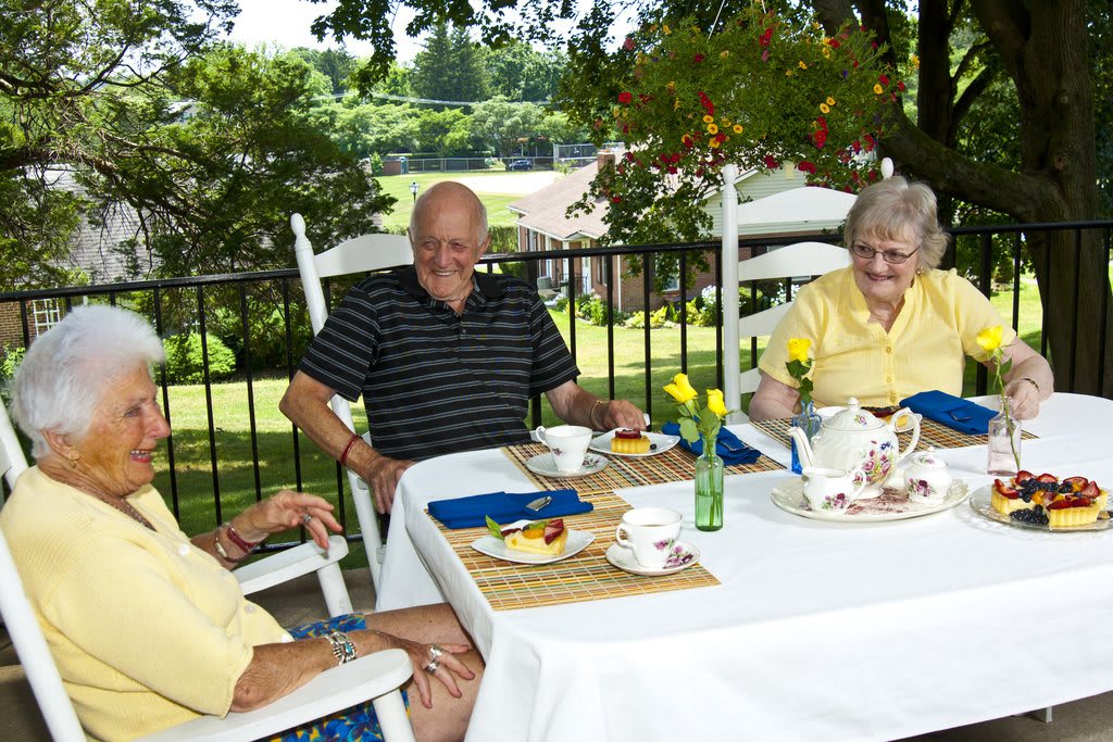 A group of seniors enjoying an outdoor teatime gathering.