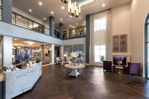 A spacious and luxurious lobby with elegant decor and a grand chandelier.
