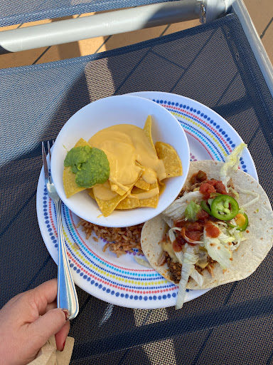 A delicious spread featuring tacos with toppings and a side of nachos with guacamole.