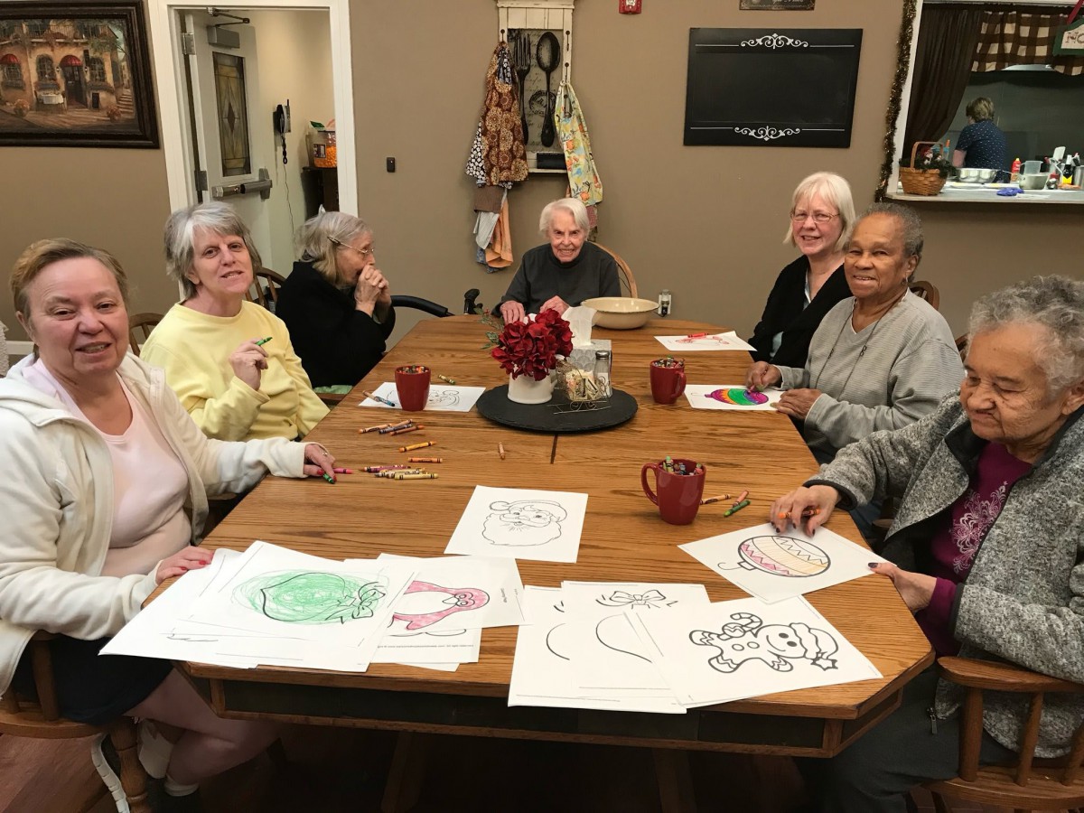 A group of seniors gathered around a table engaging in an art activity.