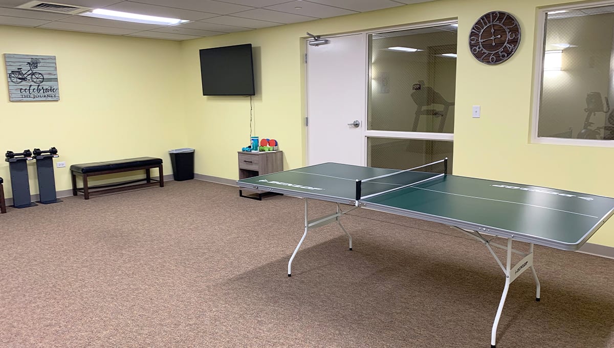 A recreational room featuring a ping pong table and a wall-mounted television.