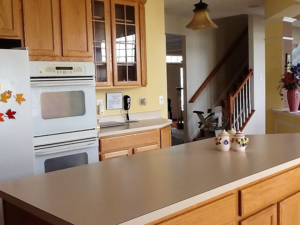 A cozy kitchen with a built-in oven and wooden cabinets.