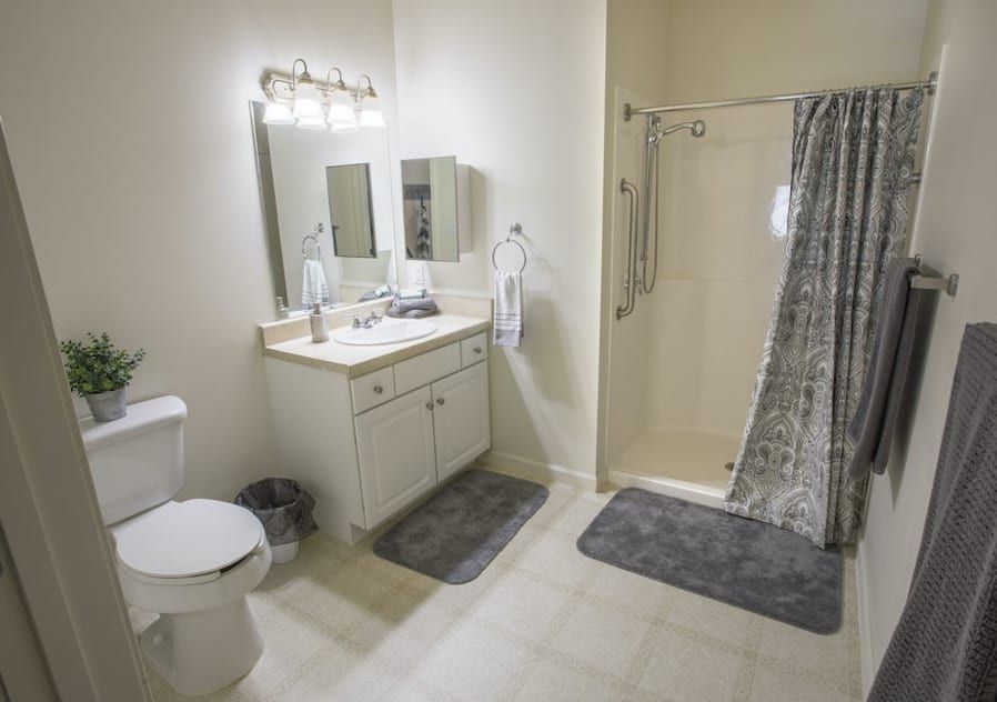 A clean and modern bathroom with a shower, sink, and toilet.