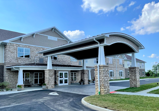 A welcoming entrance to a modern residential building with stone accents and a canopy.