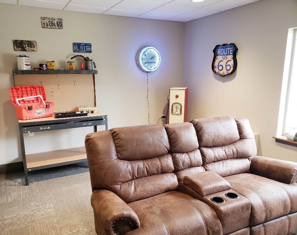 A cozy basement setup with a leather recliner, vintage decor, and a record player.