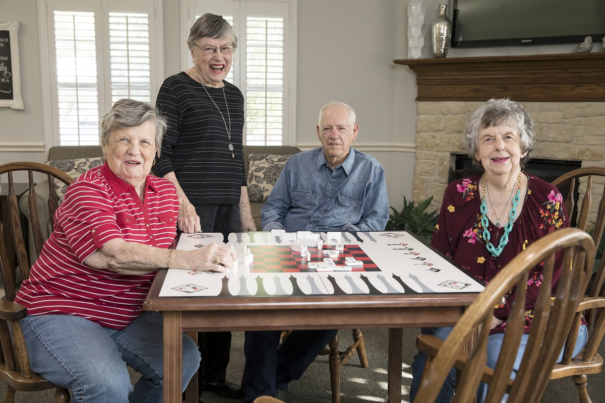A group of seniors enjoying a board game together indoors.