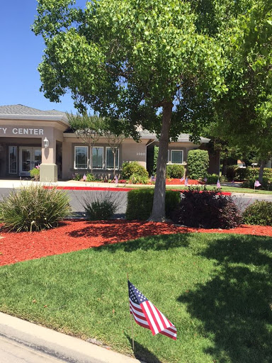 A well-maintained community center surrounded by lush greenery and vibrant landscaping.