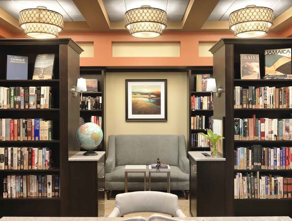 A cozy library corner with shelves full of books, a comfortable sofa, and a globe.