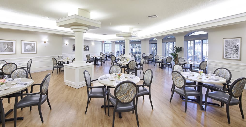 A modern dining area with empty tables and chairs, featuring elegant interior design.