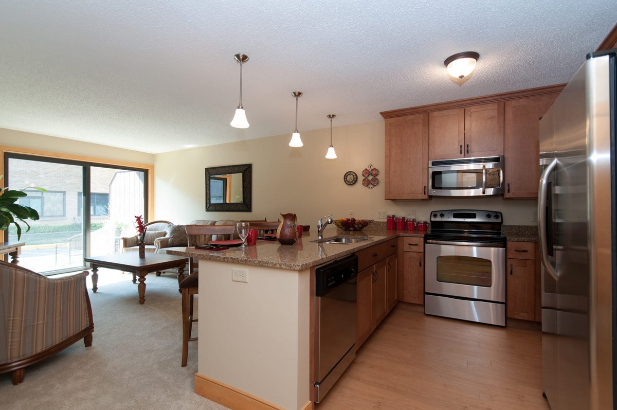 A modern kitchen with stainless steel appliances and an adjoining dining area.