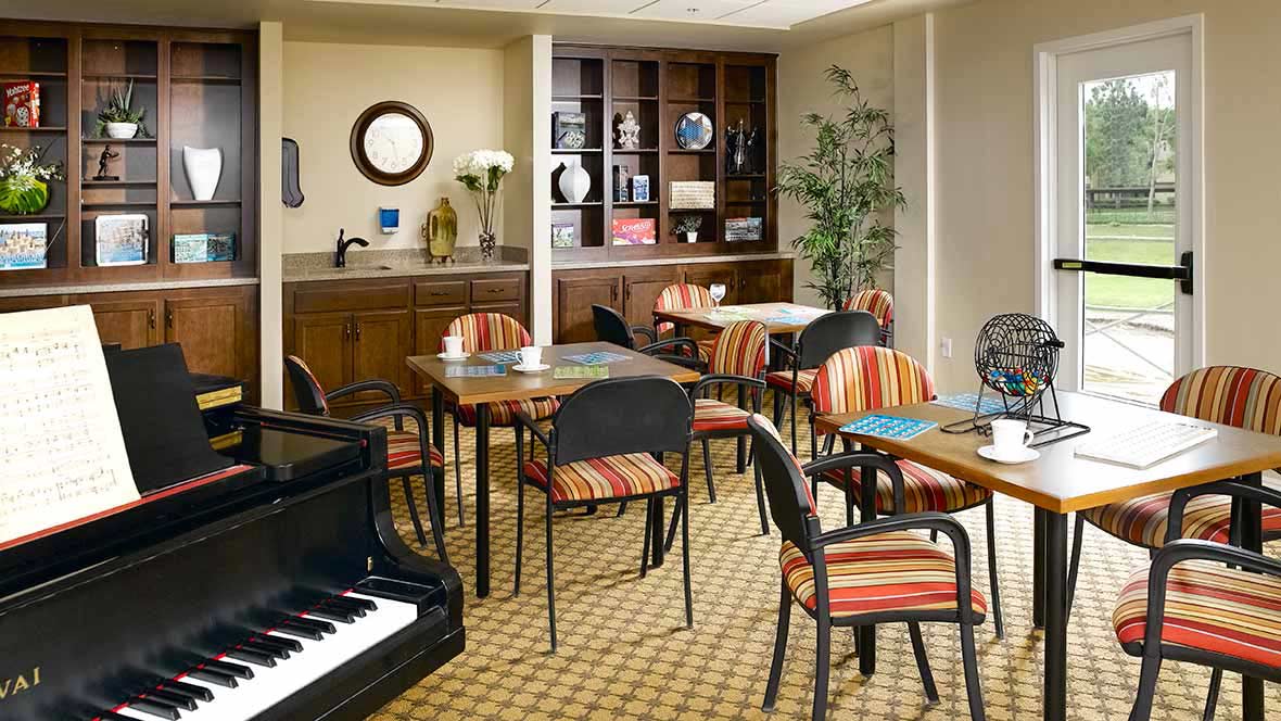 A cozy cafe interior with tables, chairs, a piano, and decorative elements.