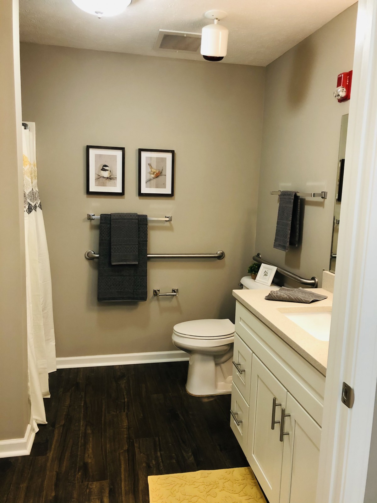 A modern bathroom with a toilet, sink, and decorative framed pictures on the wall.