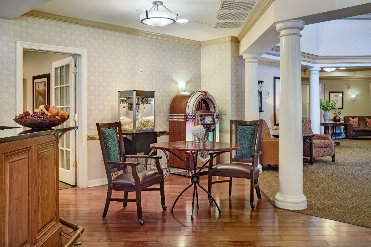 A cozy room featuring a table with chairs, a vintage jukebox, and elegant decor.