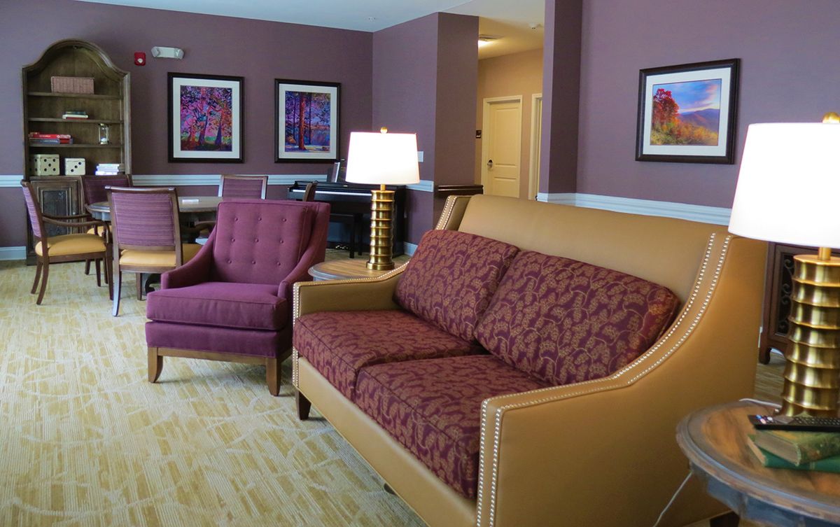 A cozy living room with a sofa and armchair set, complemented by framed artwork on the wall.