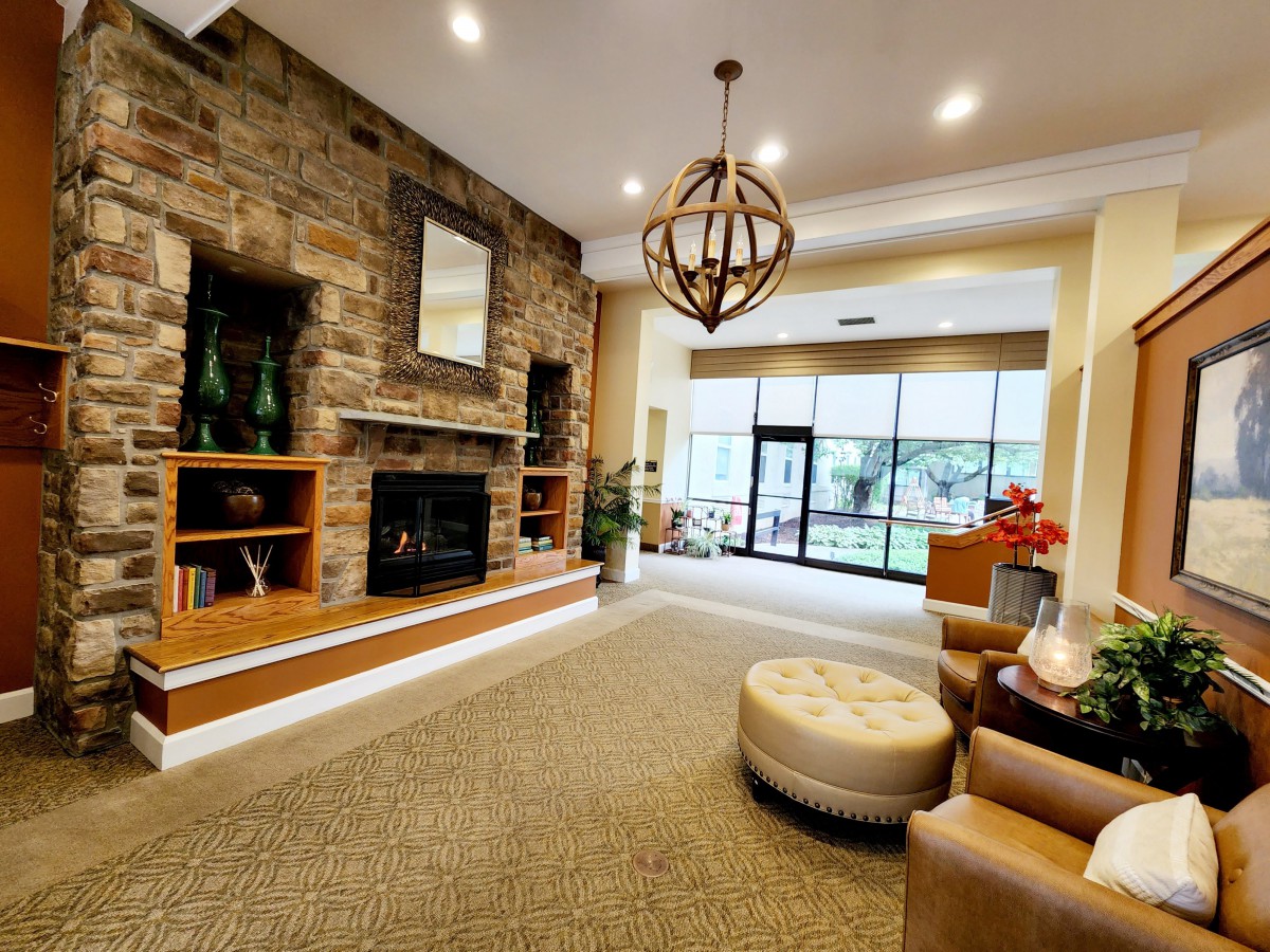 A modern lobby with a stone fireplace and seating area.