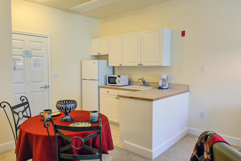 A compact kitchen and dining area with basic appliances and furnishings.