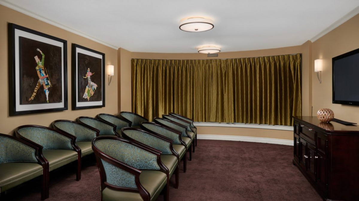 A well-arranged seating area with elegant chairs and curtains, complemented by soft lighting.