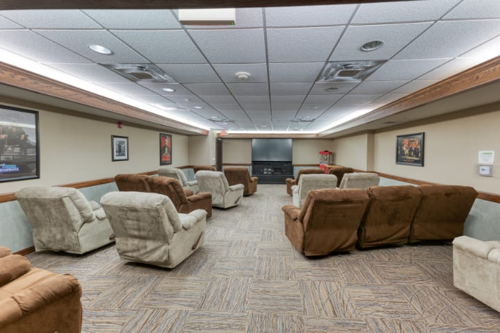 A cozy home theater setup with multiple recliners facing a projector screen.