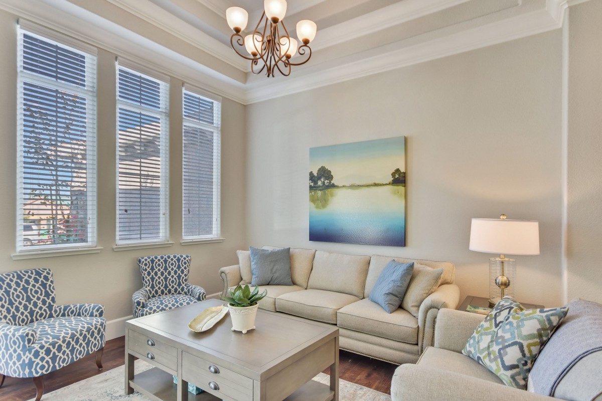 A cozy living room with a beige sofa, a wooden coffee table, and elegant lighting.