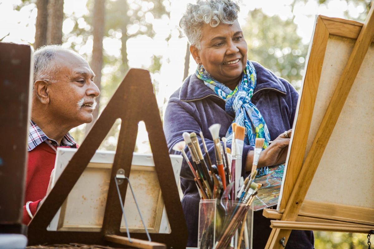 Two people enjoying painting together outdoors.