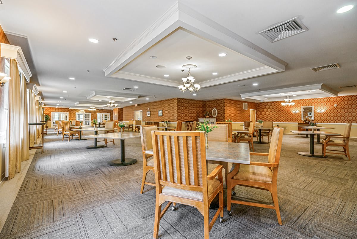 An interior view of a well-lit dining area with wooden tables and chairs.