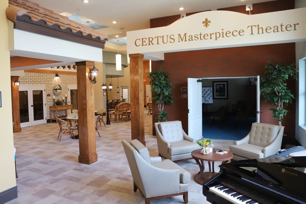 A beautifully designed lobby featuring a seating area, elegant decor, and a piano at the CERTUS Masterpiece Theater.