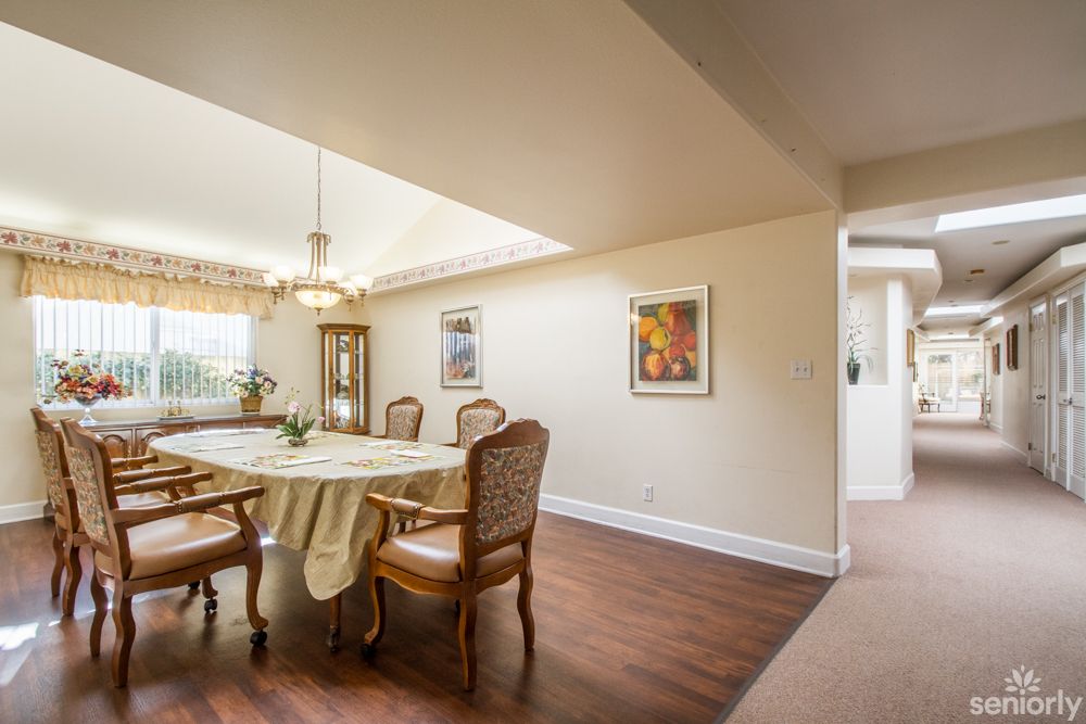 A well-lit dining room with elegant furniture and artwork on the walls.