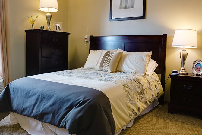 A cozy bedroom with a neatly made bed and stylish decor.