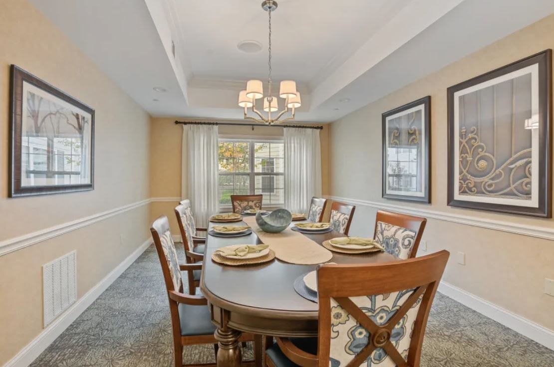 An elegantly designed dining room with a set table and chandelier.