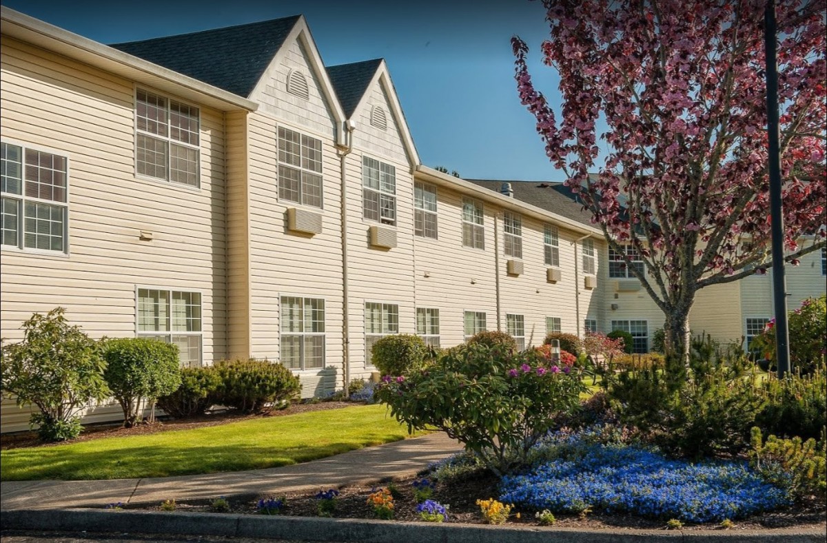 A well-maintained hotel with manicured gardens and blooming trees.