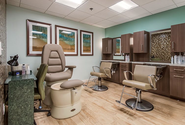 A modern salon interior with comfortable chairs and mirrors.
