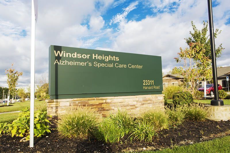 A sign for Windsor Heights Alzheimer's Special Care Center set against a landscaped background.