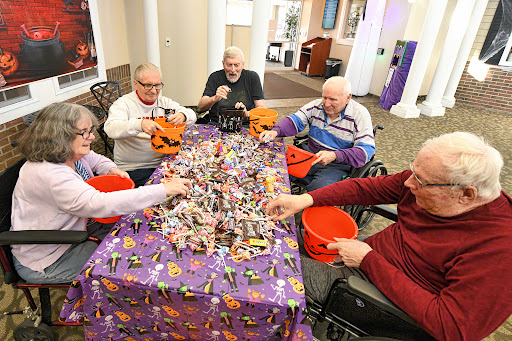 Seniors enjoying a fun Halloween candy sorting activity together.
