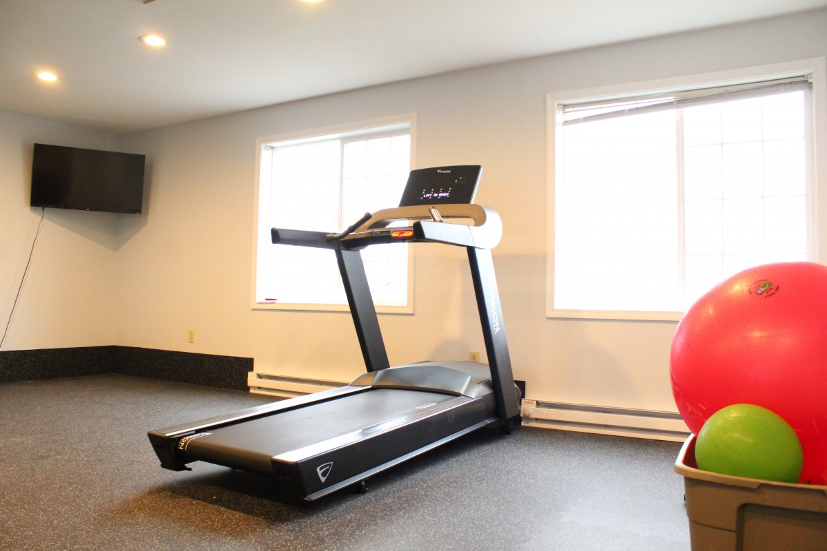 A treadmill in a well-lit gym room.