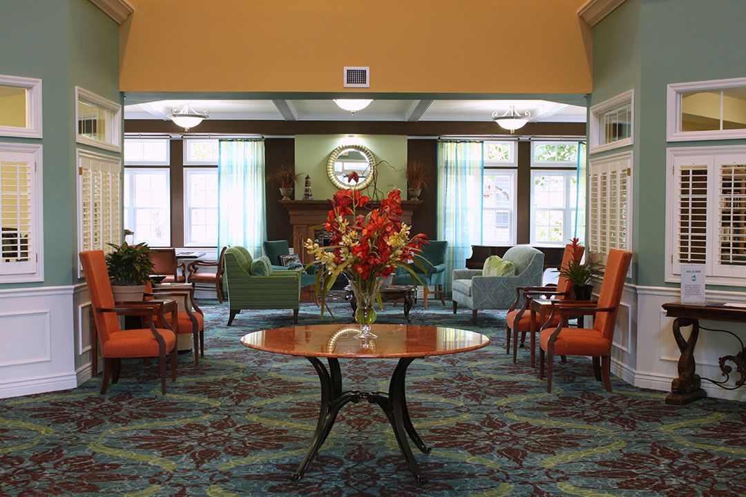 A well-decorated lobby with comfortable seating and a central table adorned with flowers.
