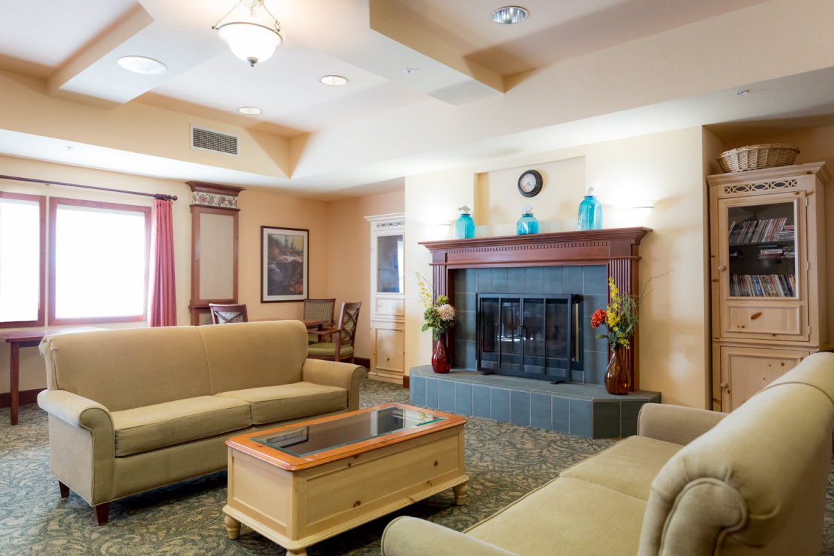 A cozy living room with sofas and a fireplace.