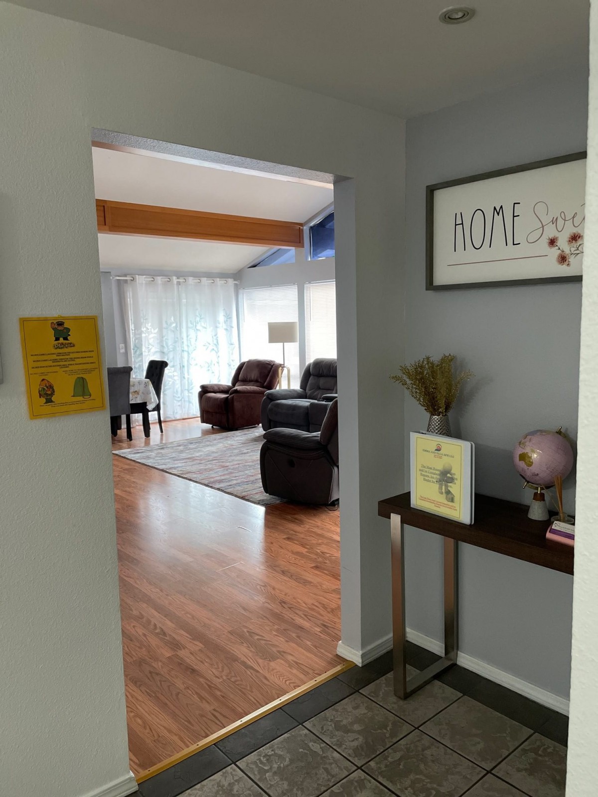 View from a hallway into a cozy living room with wooden floors and comfortable seating.