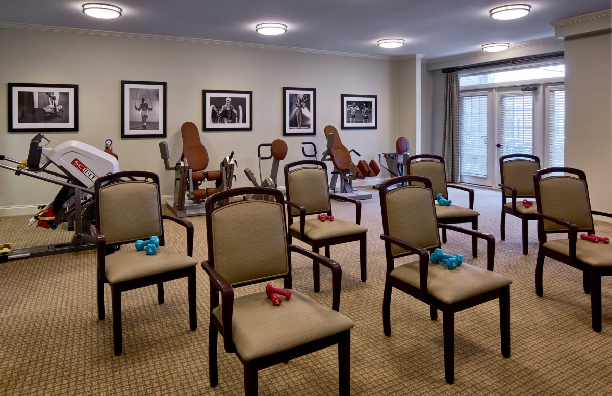 A well-organized exercise room with chairs and small dumbbells, ready for a fitness session.