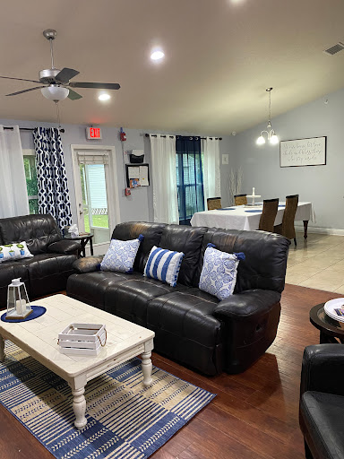 A cozy living room featuring comfortable leather sofas, a stylish coffee table, and a dining area with a modern aesthetic.