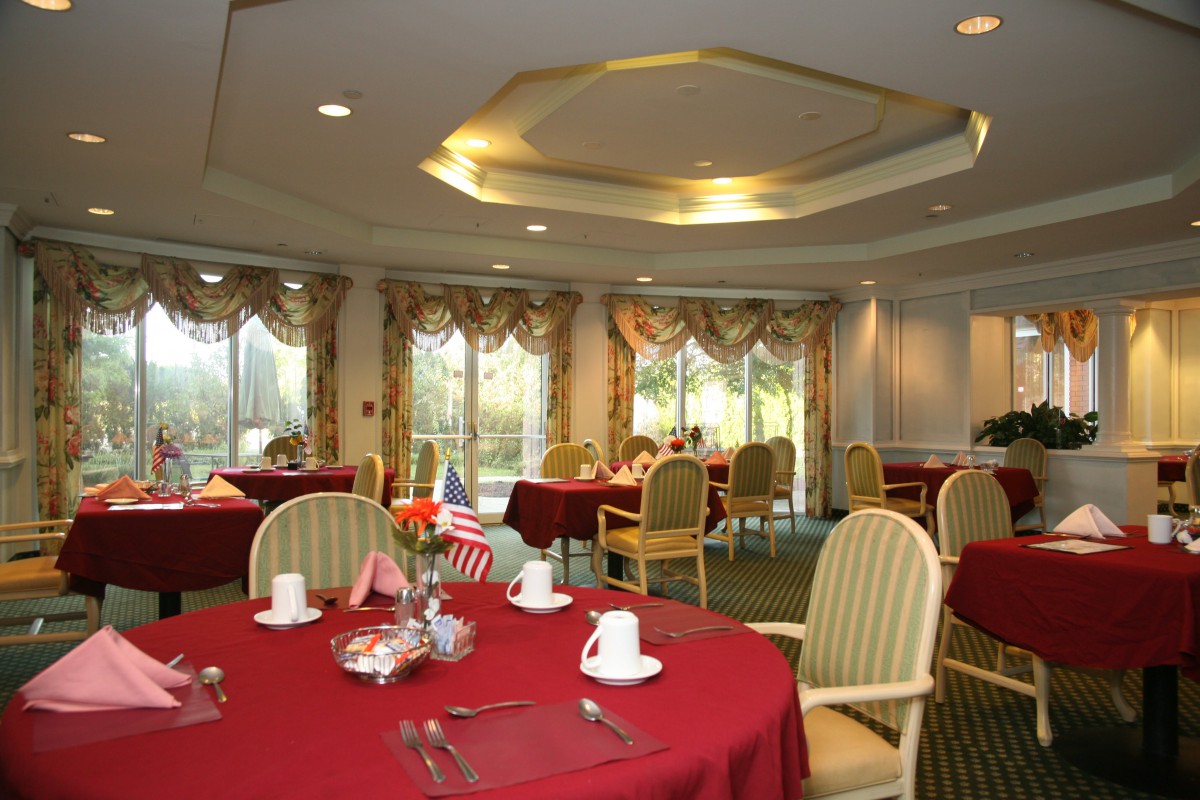 Elegant dining room with red tablecloths and decorative curtains.