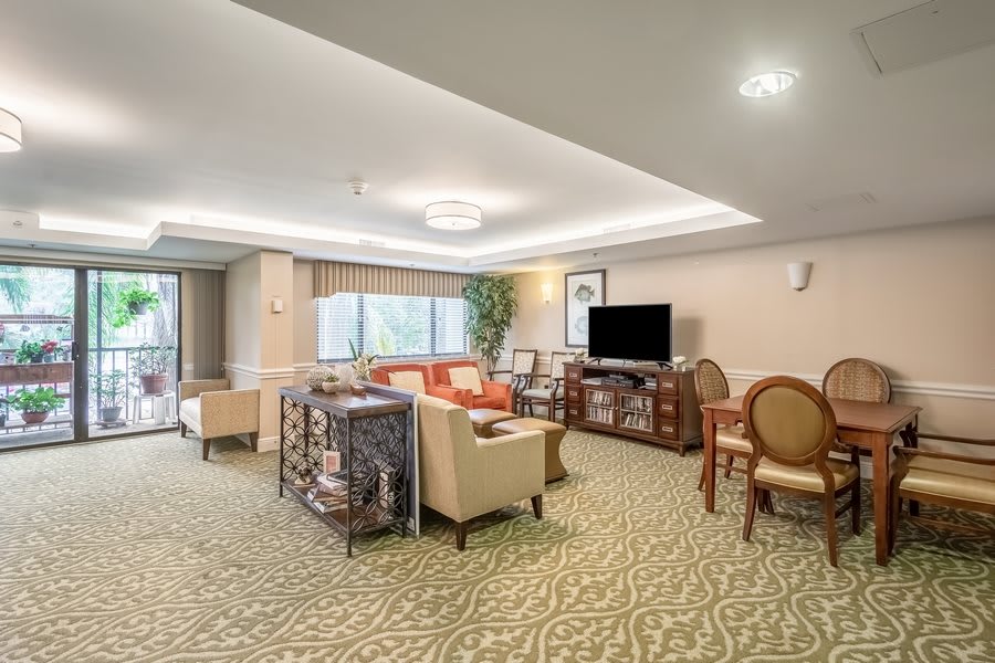 A spacious and elegantly decorated living room with comfortable seating and a television.