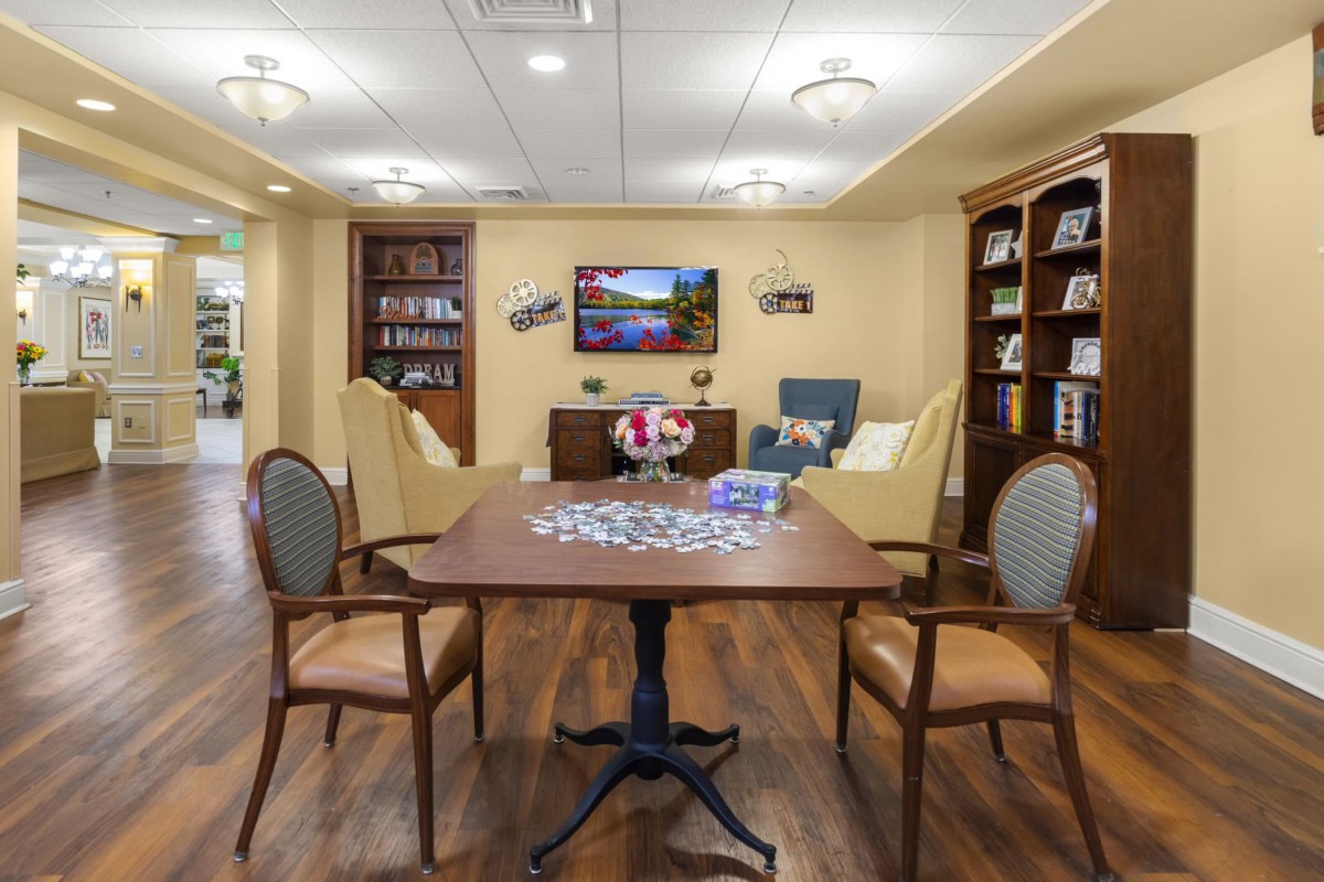 A cozy library room with a table set up for a puzzle.