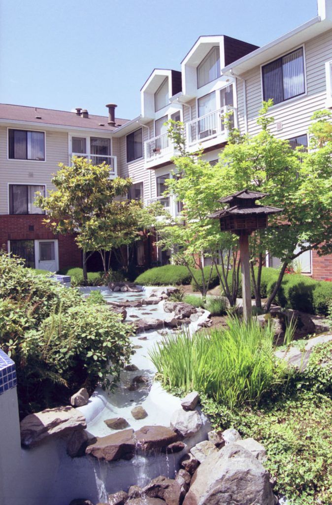 A beautifully landscaped garden in the courtyard of an apartment building.