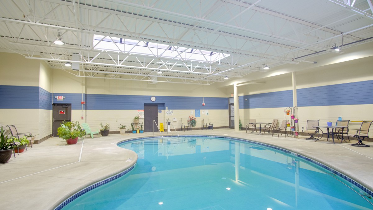 A spacious indoor swimming pool with seating area.