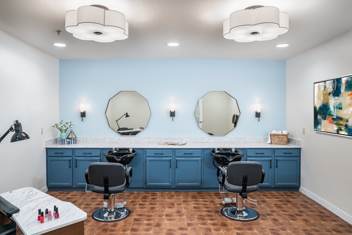 A modern salon with blue cabinets, octagonal mirrors, and stylish chairs.